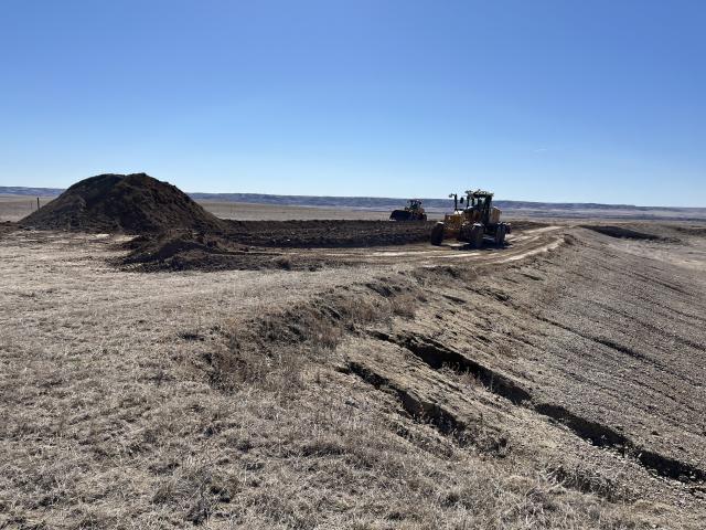 A bulldozer and scraper move dirt and rock.