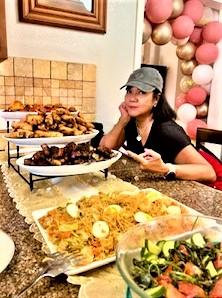Pable family friend sitting with food prepared and served at all Filipino family gatherings and celebrations.  Come and get it!