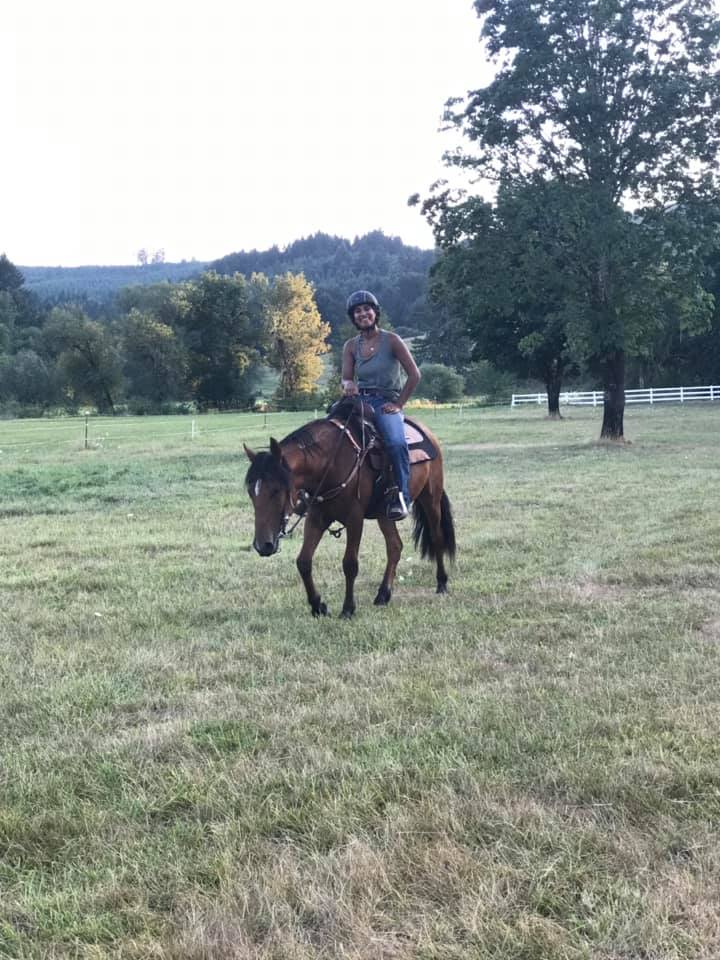 Girl riding horse in grass. 