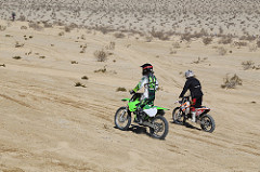 Two dirt bike riders riding on the desert trails