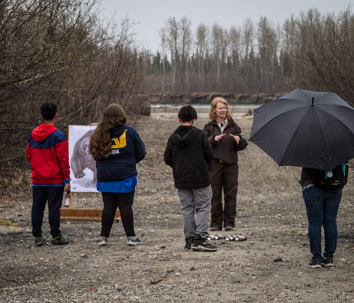 BLM park ranger and students standing on gravel