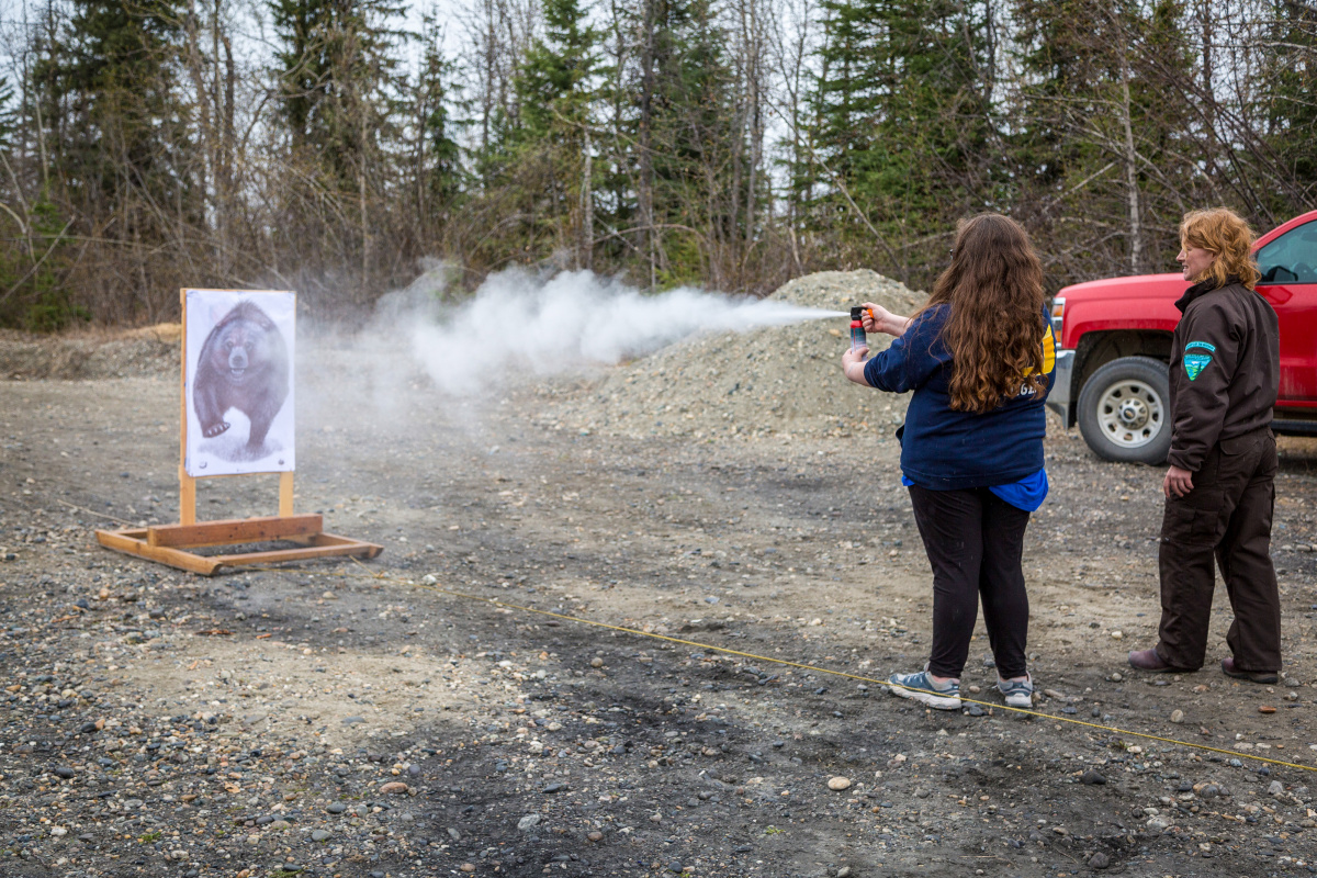 Student spraying inert bear spray at a paper target