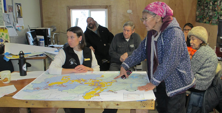 Alaska Native elder pointing to a map during a public meeting