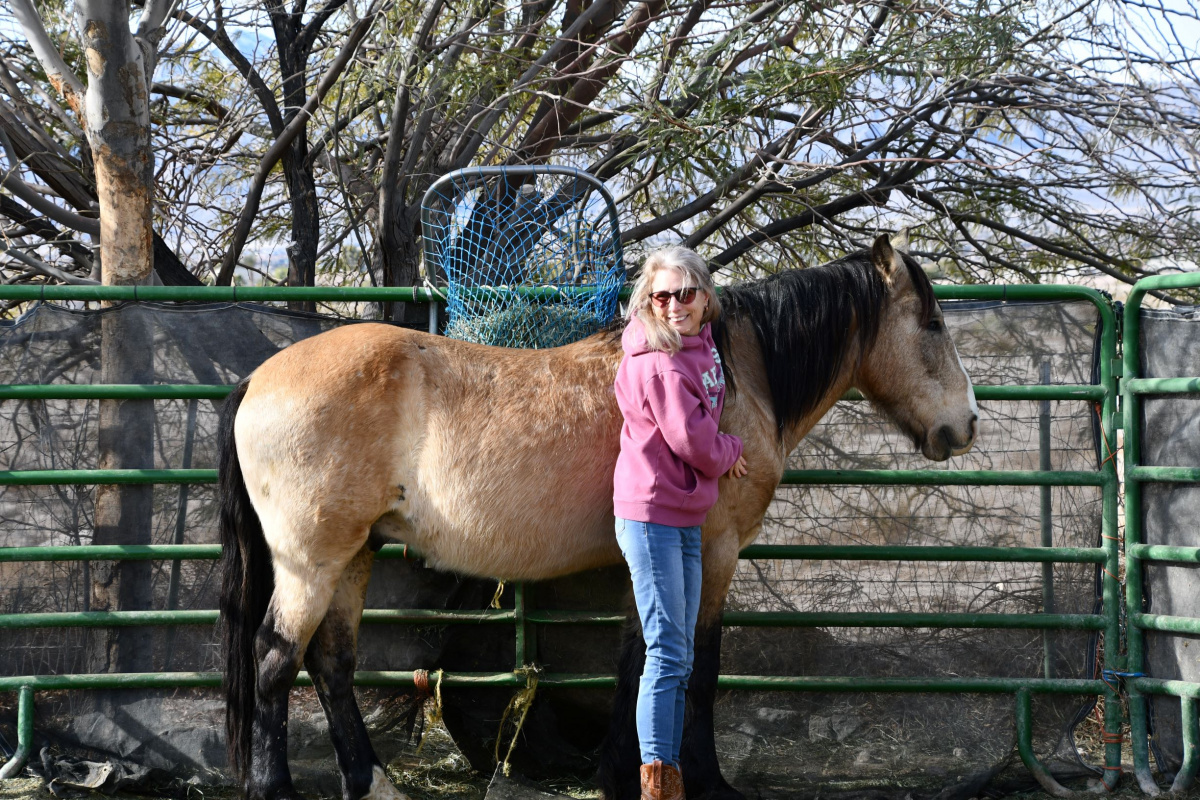 A person with her horse. 