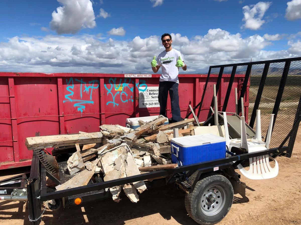 volunteer stands in trailer with trash collected during a volunteer project