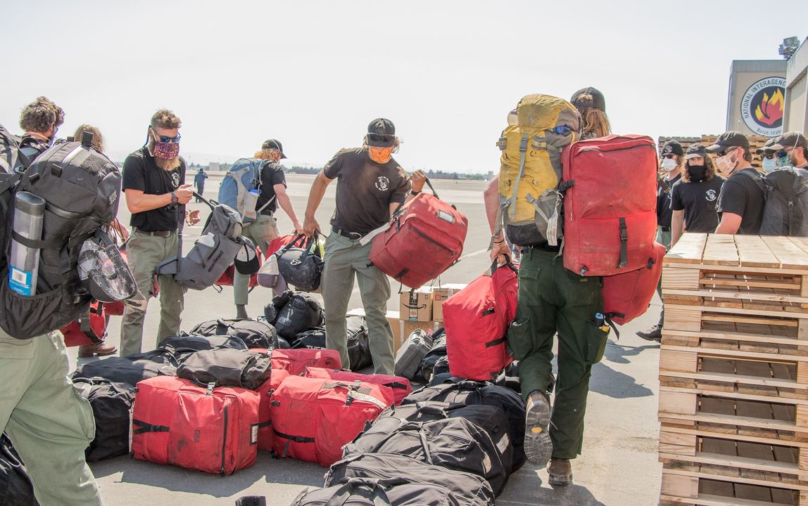 Firefighters gathering bags of gear