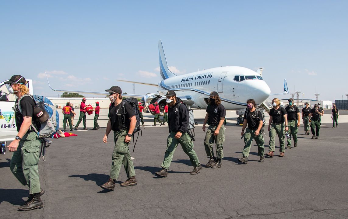 Firefighters walking past plane