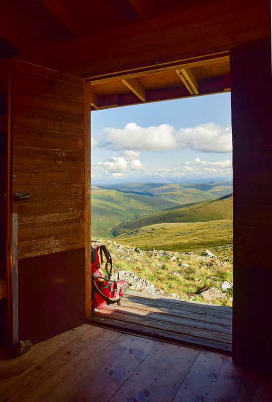 Looking into the mountains through an open cabin door