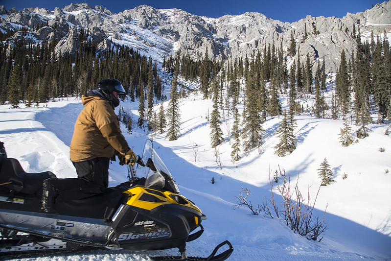 Man on snowmachine in snowy mountains