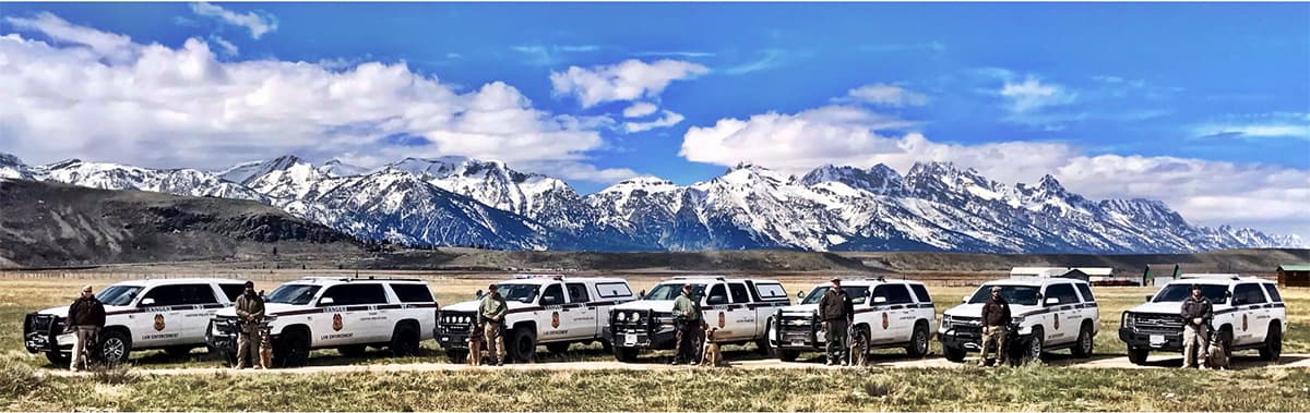 BLM Ranger K-9 teams lined up in front of them pickups