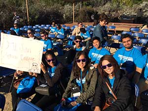 Students gather in an outdoor venue to begin the 2015 Youth Summit. One student holds a sign "Mt. San Antonio College."