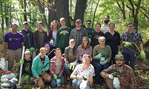 A group of college students pose in a wooded area on an island in the Wisconsin River.