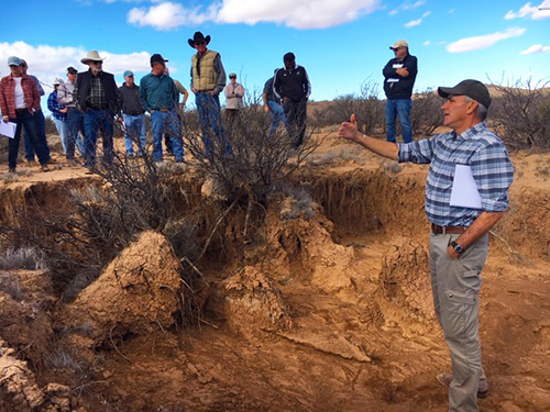 Jack Barnitz, Branch Chief of Biological and Watershed for BLM Las Cruces District, shows members of the tour some of the effects of erosion.