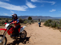 Image of a motorcycle rider on a dusty track. Photo by Marisa Williams/BLM