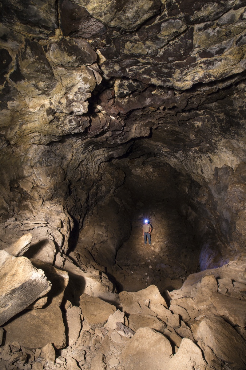 A man stands inside a cave in Idaho. BLM photo.