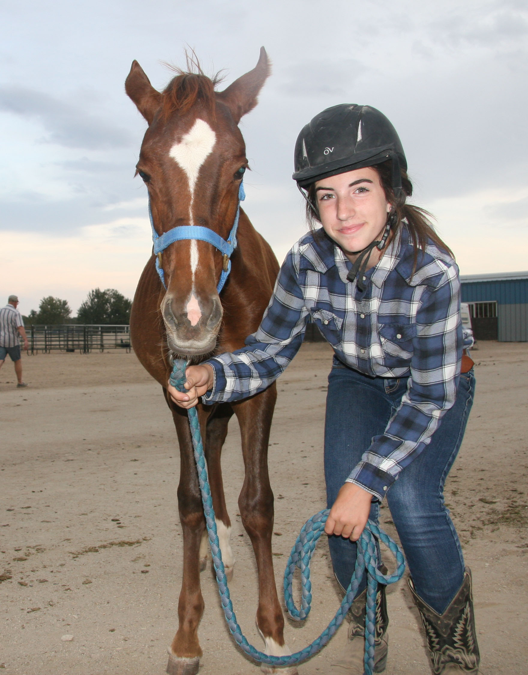 An Idaho 4-H member stands proudly with the mustang she is gentling as part of the partnership with BLM.