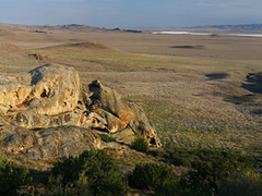 Rock outcrop overlooks a large valley.  Photo by Bob Wick, BLM.