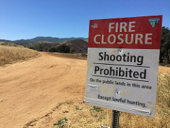 A sign near a dirt road tells visitors of a fire closure and shooting restrictions in the area.  Photo by Michelle Puckett, BLM.