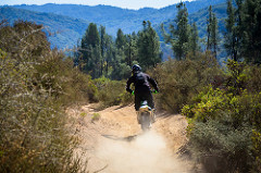 A motorcycle rider on a dirt trail in the Cow Mountain Off-Highway Vehicle Area.  Photo by Thomas Delgado, BLM Volunteer.