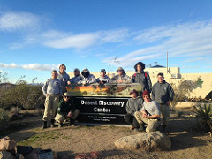 A group of Americorps interns and volunteers stand in from the of the Desert Discovery Center sign.  (BLM Photo)