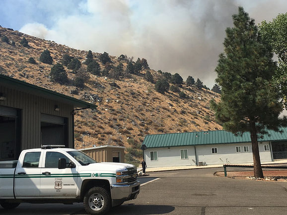 Smoke from a wildfire rises above a mountain ridge.  Photo by Tim Dunfee, USFS.