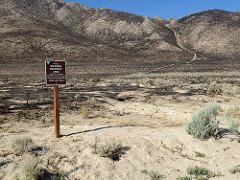 Wide-open mountain area scarred by a wildfire with a BLM sign that reads "Entering Wildfire Recovery Area, your help is needed, motorized vehicles please stay on designated roads and trails." Photo by Marisa Williams, BLM.