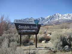 A BLM sign at the entrance to the Goodale Creek Campground with snow covered mountains in the background (BLM Photo).