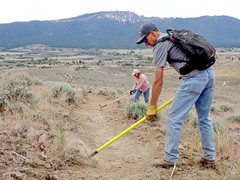 Three volunteers contsruct trails in the new  Bald Mountain trail system by clearing rocks and smoothing the trails. Photo by Stan Bales, BLM.