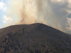 Smoke rises over a hill at the Slinkard Fire (BLM Photo)