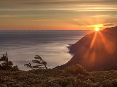 The sun sets over the ocean just behind a mountain on the coast of California.  Photo by Bob Wick, BLM.