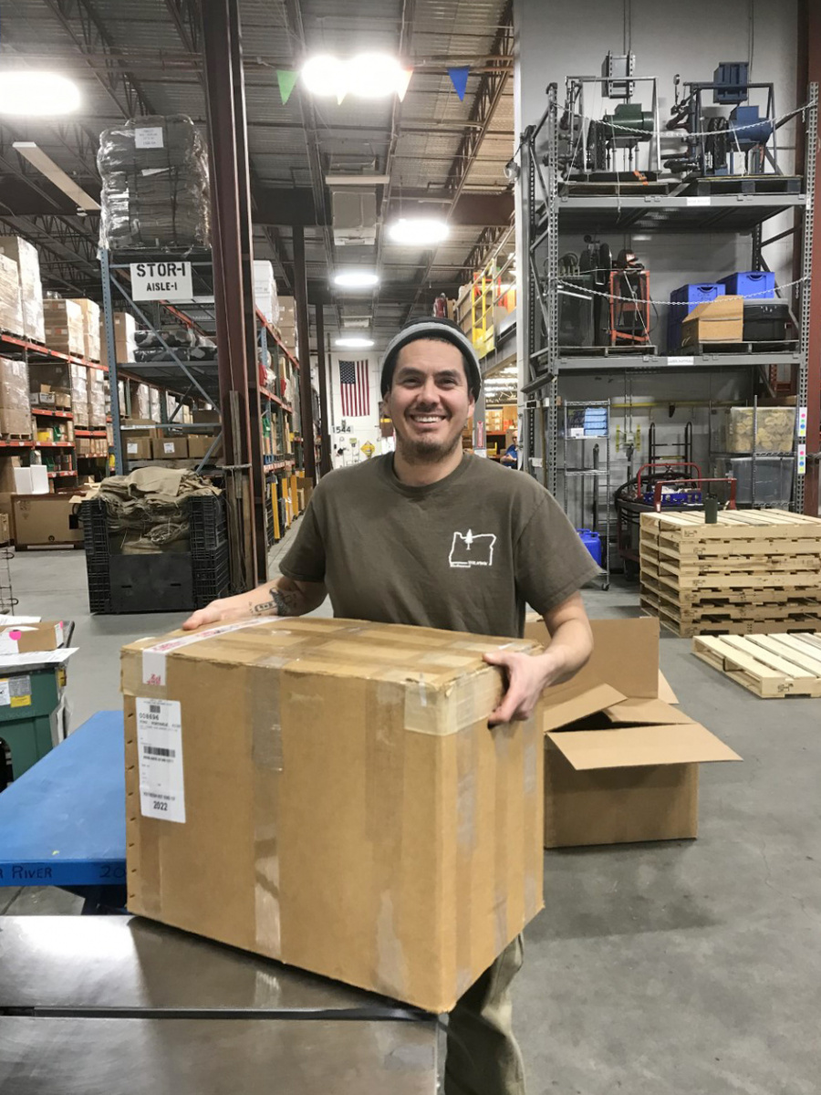Warehouse worker holds box of equipment