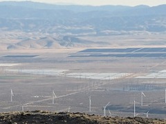 A desert valley with a solar array and wind turbines. Photo by Marty Dickes, BLM. 