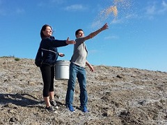 Two volunteers tossing seeds in the air. (BLM Photo)