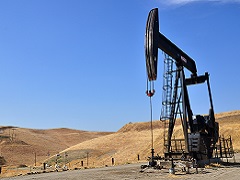 Oil derrick in rolling grassy hllls. Photo by John Ciccarelli/BLM.