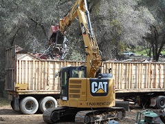 An excavator moves trash into a dump truck. Photo by Peter Graves/BLM.