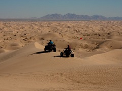 Two atvs ride dunes into the horizon. Photo by Jim Shepard/BLM.