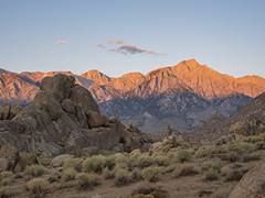 Rock formation in the forefront with mountains in the background.