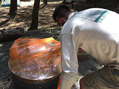 A volunteer warping a fire-ring in plastic.