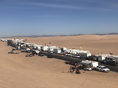 Photo of campers and off road vehicles at a camp in between dunes. Photo by Sarah K. Webster/BLM.