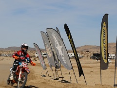Image of a dirt bike coming into the finish line at sand dunes.