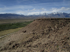 Image of flat volcanic formation with snowy peaks in background. Photo by BLM.