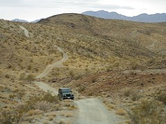 Image of a jeep driving through rocky, yellow hills. Photo by BLM.