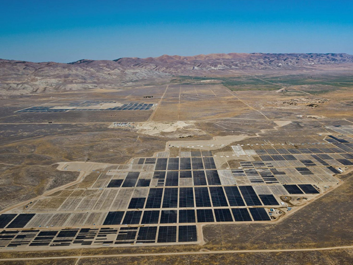 An aerial photo of solar panels in a desert land scape