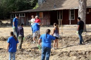 Volunteers working around a historic cabin