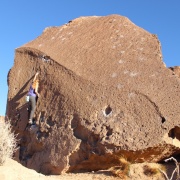 Person climbing large rock feature