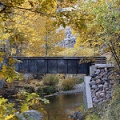 photo of bridge over creek with colorful trees