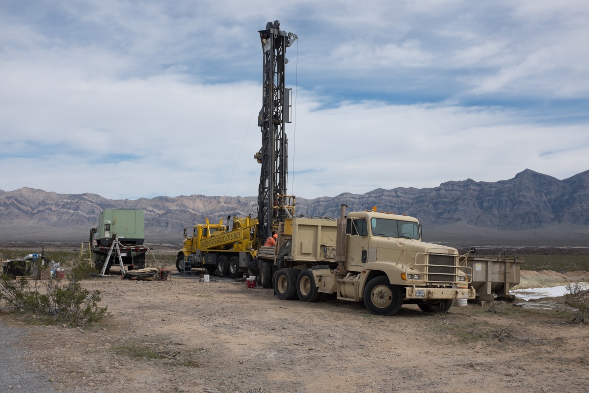 Large trucks and equipment drill a well in a remote area in the Chicago Valley.