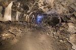 A man with a hardhat stands inside Craters of the Moon in Idaho. Photo by Bob Wick, BLM.