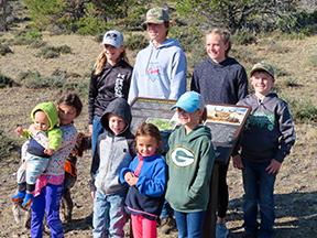 Youth volunteers surrounding newly installed interpretive sign