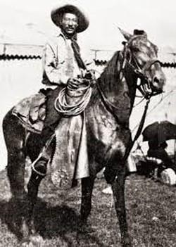 Historical photo of a black cowboy riding a horse